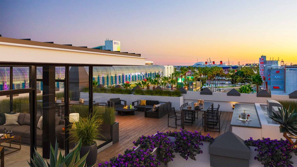 Sunset image of the Ocean Center Apartments rooftop deck with views of the Queen Mary in the background.