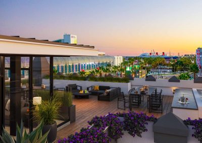 Sunset image of the Ocean Center Apartments rooftop deck with views of the Queen Mary in the background.